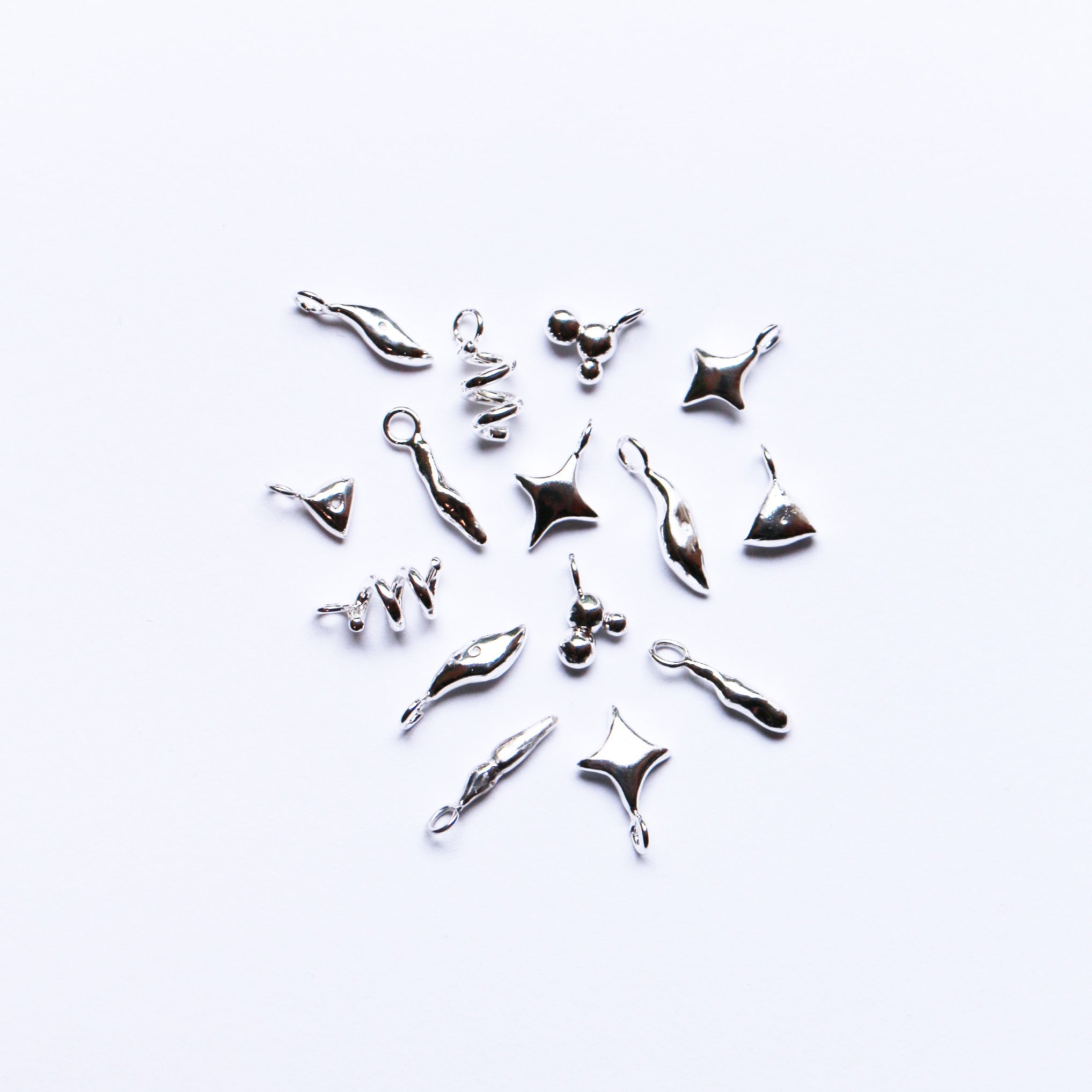 charms collection in an unorganized maner but forming a circle, resembling a microscopic image of diatoms.